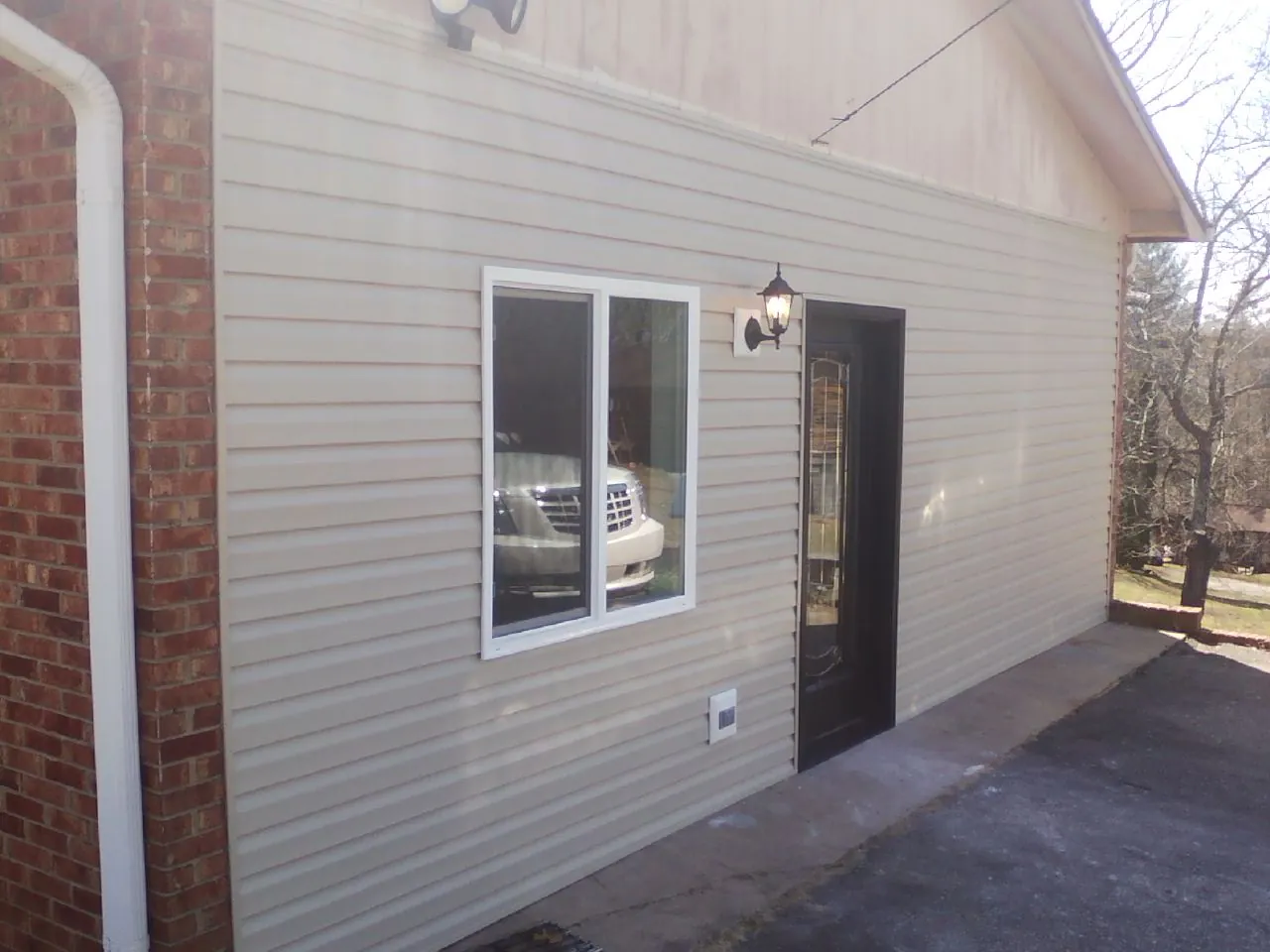 New vinyl siding and entry door on a room addition in Plantsville