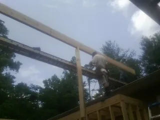 Carpenter setting a ridge beam over a new addition frame — Ice Dam Removal by Roofing Brothers in Plantsville