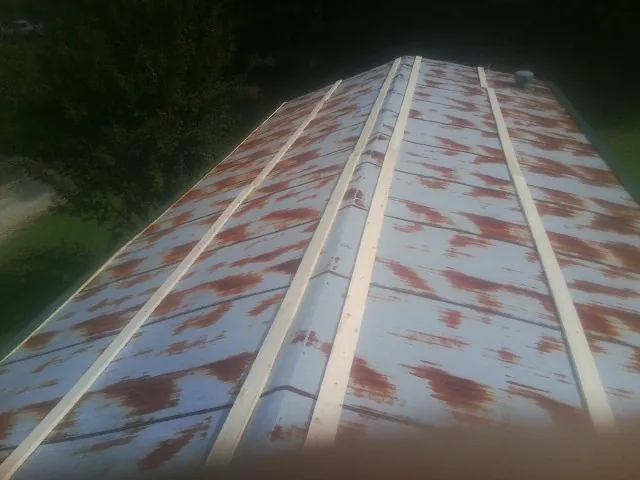 Rusted metal roof panels with new wood purlins before replacement — Storm Damage Roof Repair in Plantsville by Roofing Brothers