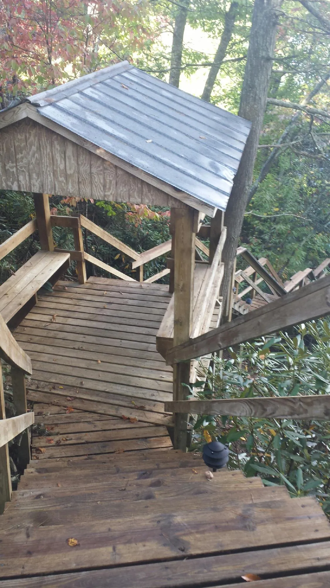 Metal roofed shelter over wooden steps on a wooded walkway — Skylight Repair & Installation work by our crew in Plantsville
