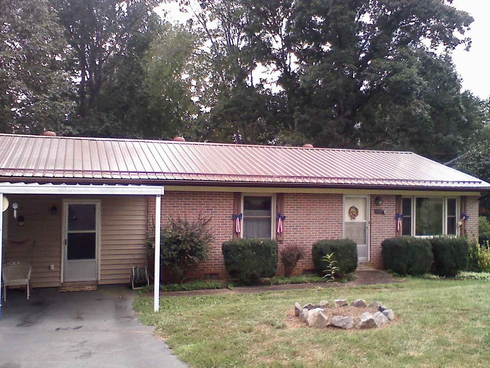 Bronze metal roof and carport on a brick ranch home — Roof Repair work by our crew in Plantsville